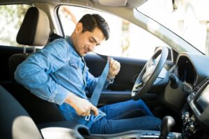 Man buckling his seat belt.